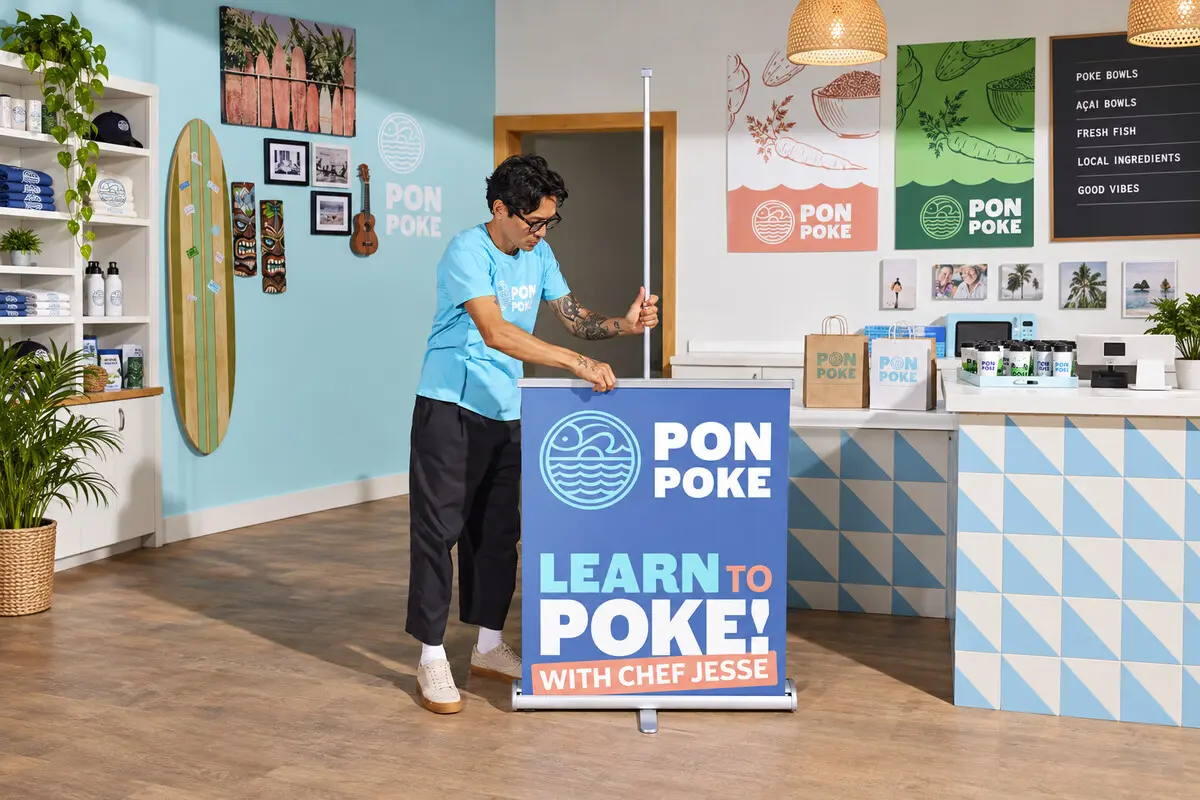 Thao tác kéo tấm in lên khi dựng standee cuốn tại nhà hàng