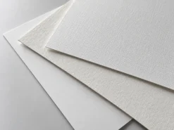 Các tờ giấy mỹ thuật trắng và trắng ngà chưa in với bề mặt có vân nhẹ.