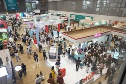 Khách tham quan đi giữa các dãy gian hàng trong hội trường triển lãm rộng.