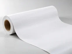 Cuộn vật liệu PP trắng chưa in được trải ra trên nền xám sáng.