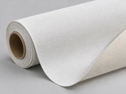 Cuộn canvas trắng ngà chưa in với phần vải trải ra, nhìn rõ cấu trúc dệt.