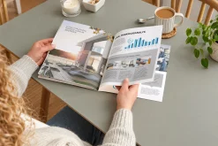 Người đọc catalogue nội thất có biểu đồ trên bàn ăn