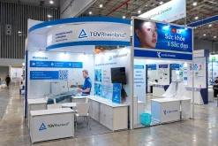 Gian hàng TÜV Rheinland màu xanh trắng với quầy, tủ trưng bày và bảng giới thiệu.