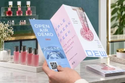 Tờ gấp sự kiện làm đẹp đặt cạnh các lọ sơn móng