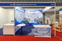 Thi công gian hàng triển lãm Fluoroplast Solutions lô B1241–B1242: vách in đồ họa xanh trắng, quầy tiếp khách và bảng hiệu phía trên.