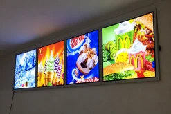 Dãy khung tranh đèn LED treo tường hiển thị hình đồ uống và thức ăn nhanh.